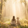 Femme et son chien dans une forêt lumineuse symbolisant le deuil animal et l'accompagnement hypnose à Pézenas